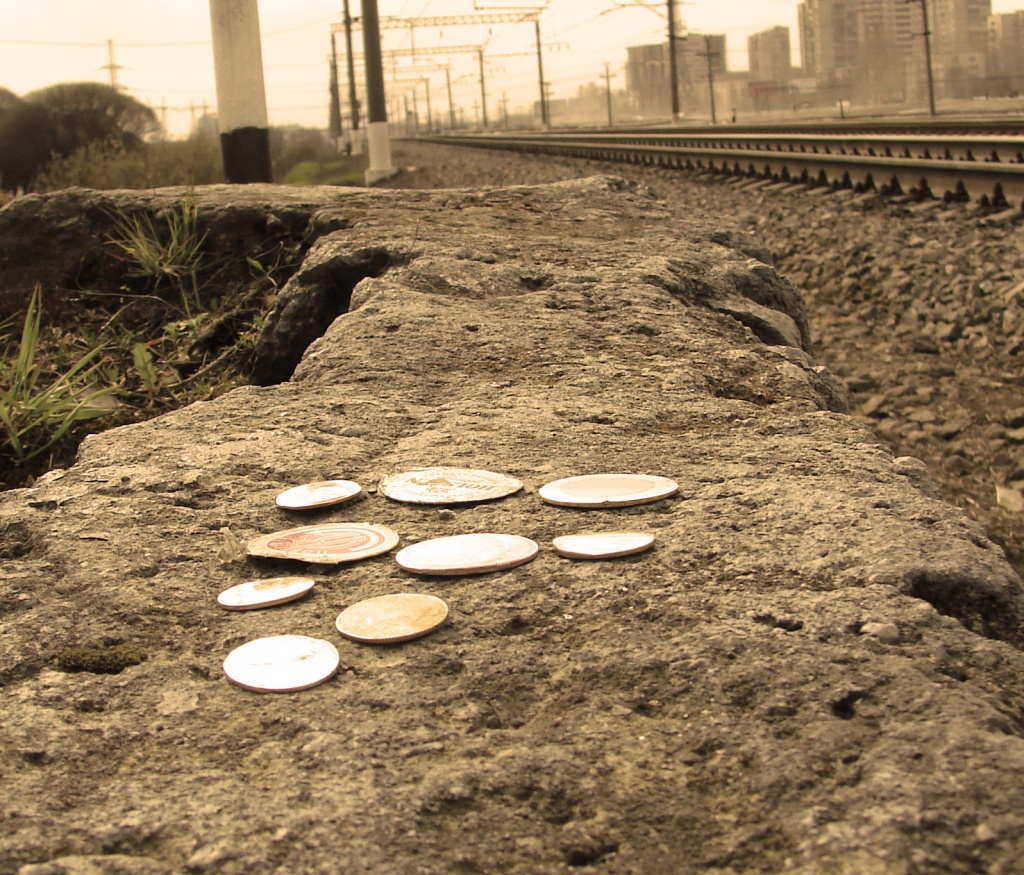 Монеты и пробки от пивных бутылок раздавленные поездом